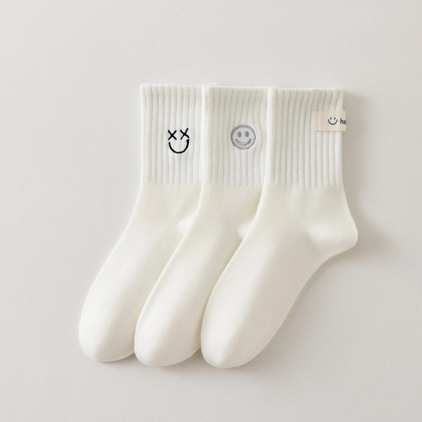 Lot de 3 chaussettes blanches montantes avec smiley, confortables et stylées, idéales avec des baskets. Coton épais, look tendance et maintien optimal.