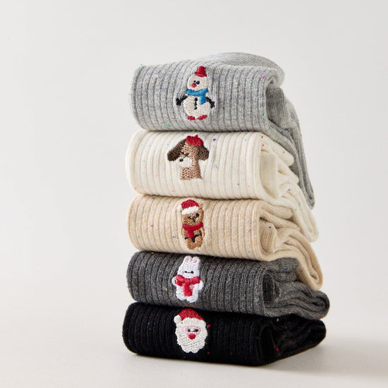 Lot de 5 chaussettes femme hautes à broderies de Noël. Motifs festifs : renne, Père Noël, pingouin... Maille chaude et douce. Taille unique 35-41.