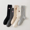 Lot de 5 chaussettes femme hautes à broderies de Noël. Motifs festifs : renne, Père Noël, pingouin... Maille chaude et douce. Taille unique 35-41.