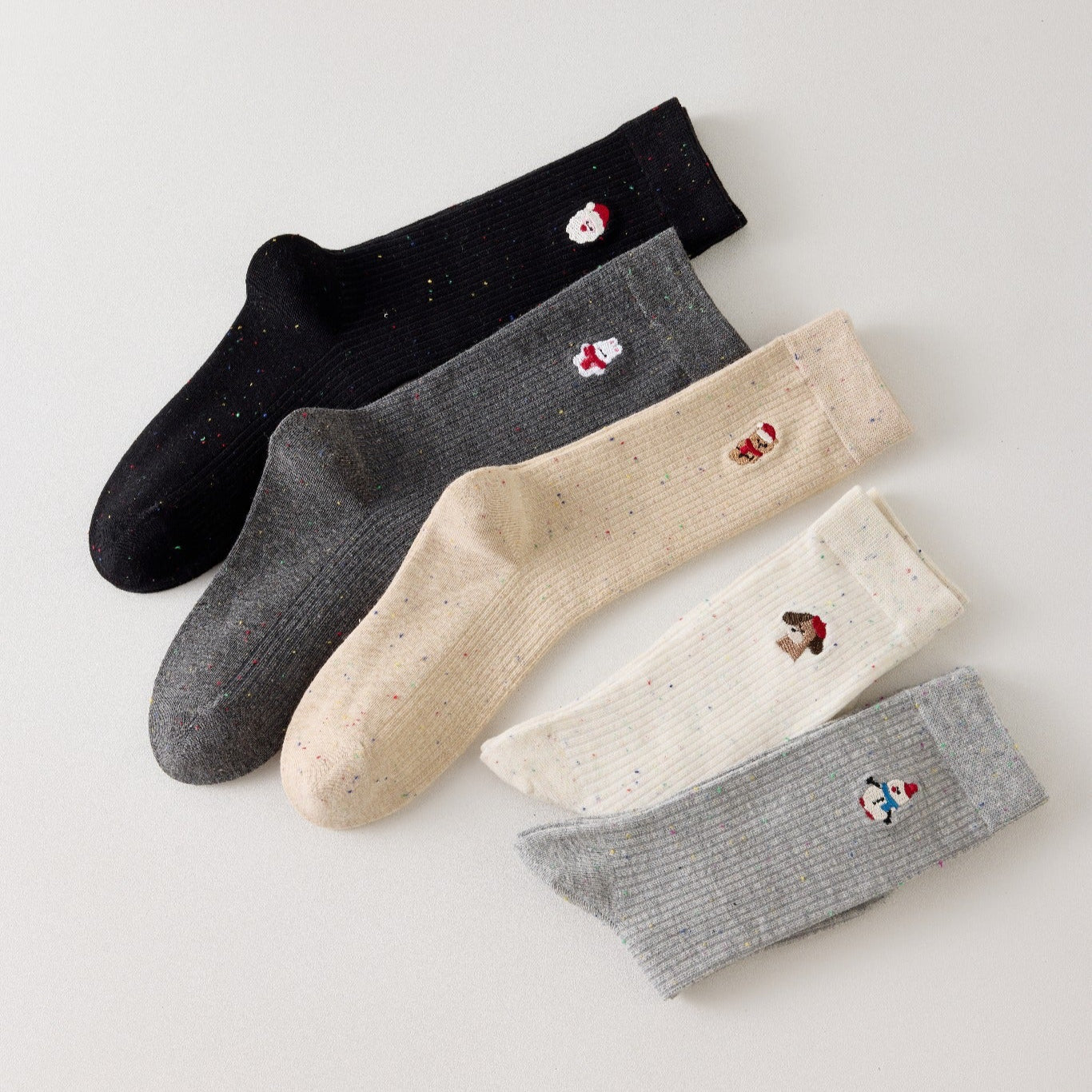 Lot de 5 chaussettes femme hautes à broderies de Noël. Motifs festifs : renne, Père Noël, pingouin... Maille chaude et douce. Taille unique 35-41.