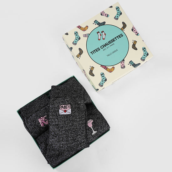 Lot de 5 chaussettes paillettes et fêtes. Lurex argenté noir. Motifs festifs bridés : coupes de champagne, boule à facettes, verre à cocktail, invitation, chaussures à talon. Joli coffret carton Tites Chaussettes. Idéales pour les fêtes et pour offrir. 