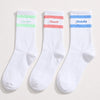 Chaussettes blanches, 2 bandes contrastées vert pastel, rose ou bleu.
Broderie Love You, Beauté ou Bichette. 
Chaussettes montante esprit sport.