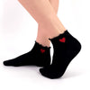 Chaussettes basses unies volantées. Cœur rouge discret, coton doux, noir ou blanc. Confortables, féminines et idéales pour la mi-saison.